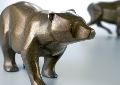 statue of a bear with a bull in the background
